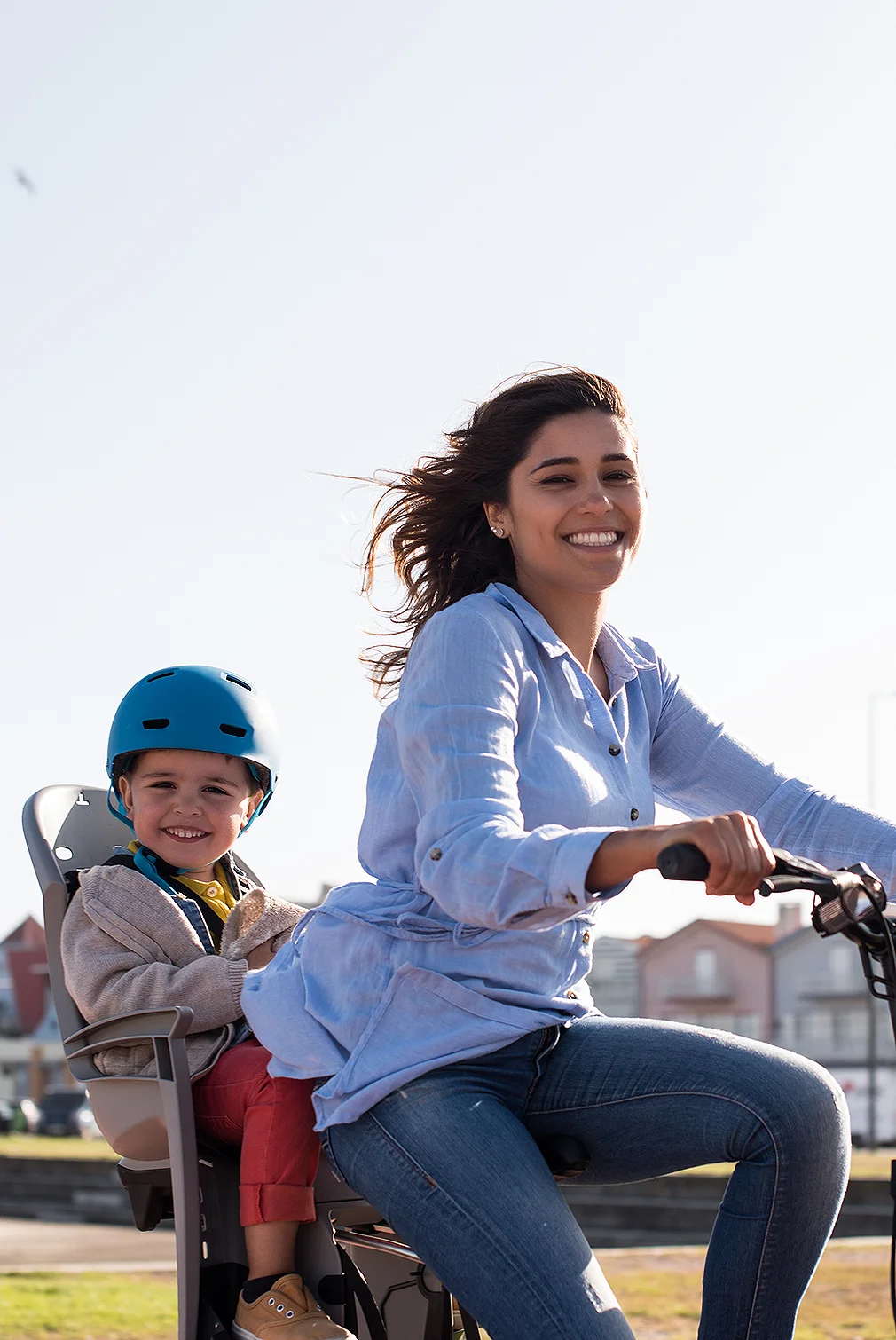 A mother cycling with her toddler in a child seat